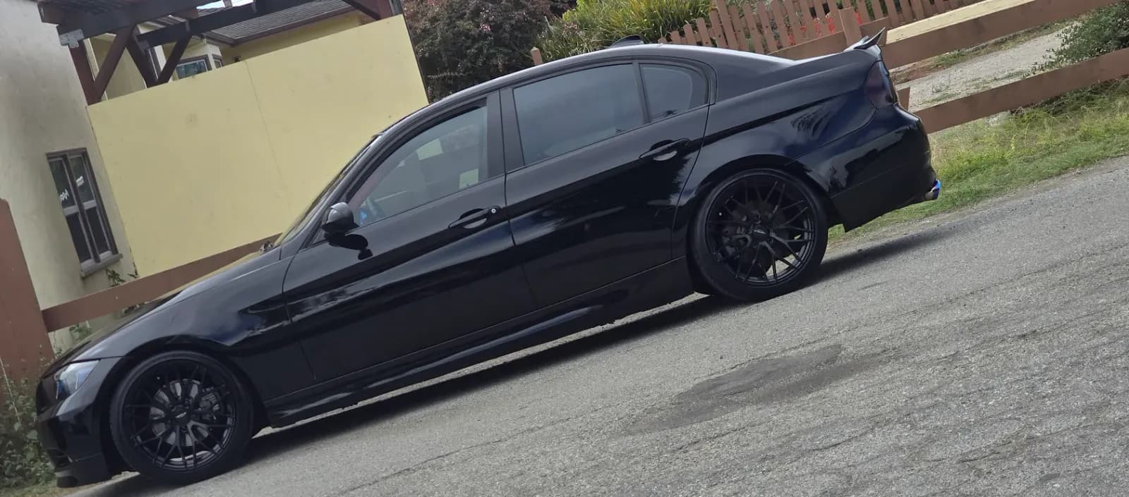 Black sedan parked in a driveway after a Fast Clean Mobile Detailing exterior detail.